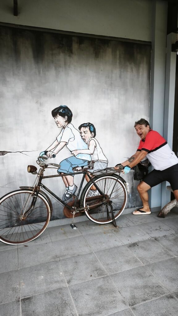 Maurice pushing a bicycle in Thailand